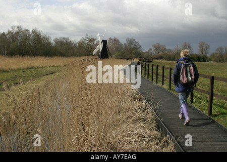 Eine Frau, die zu Fuß in der Wicken Fen Windpumpe, Wicken Fen, Norfolk, England Stockfoto
