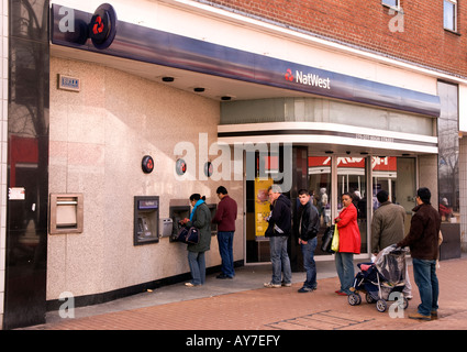 Kunden in der Warteschlange mithilfe von Nat West Bank Cashpoint Maschinen, High Street, Hounslow, Middlesex, Großbritannien. Stockfoto