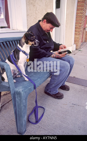 Herr 711 Wayne Gornto und seinem Hund Tex entspannen Sie auf einer Bank mit Blick auf die Plaza in Las Vegas, New Mexico. Stockfoto