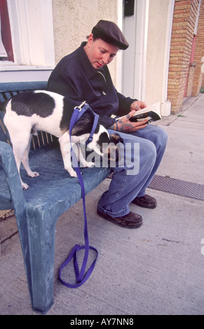 Herr 711 Wayne Gornto und seinem Hund Tex entspannen Sie auf einer Bank mit Blick auf die Plaza in Las Vegas, New Mexico. Stockfoto