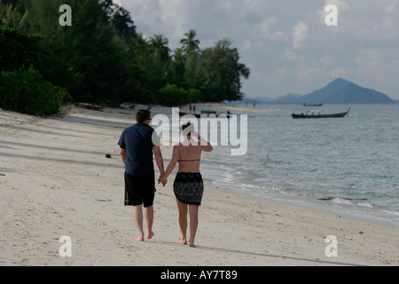 Mann und Frau im Sarong schlendern Sie entlang ruhiger Strand Ko Ngai Insel Thailand Stockfoto