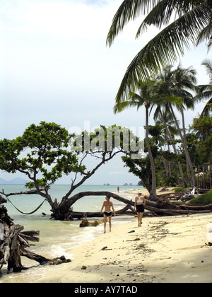 Zwei Frauen gehen am palmengesäumten Strand Ko Ngai Insel Thailand Stockfoto