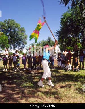 Hispanischen Mädchen Amanda Sanchez nimmt einen Schlag an den Preis gefüllt Pinata, die Pinata fest in Poe Mais Park, Roswell, New Mexico. Stockfoto