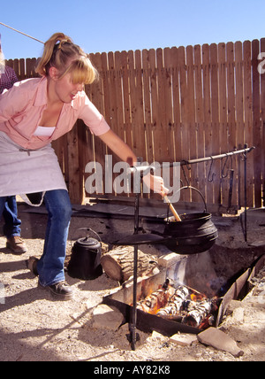 Ein Teenager Chuck Wagon Koch rührt den Topf, an der New Mexico Farm und Ranch Heritage Museum in Las Cruces, New Mexico. Stockfoto