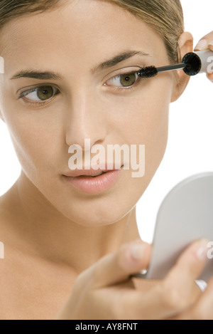 Frau, setzen auf Mascara, in der hand Spiegel, close-up Stockfoto