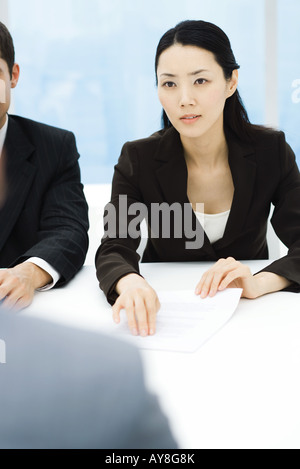 Business Associates im Meeting, Geschäftsfrau, Dokument, durchhalten Blick über Tabelle Stockfoto