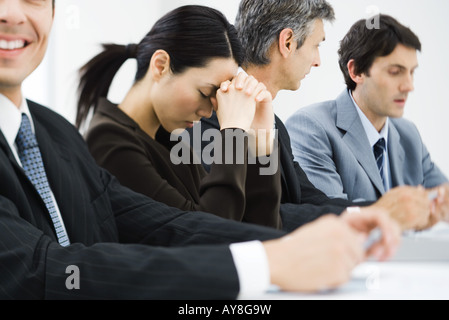 Führungskräfte im Business-Meeting, Frau schließen Augen und schiefen Kopf gegen die Hände Stockfoto