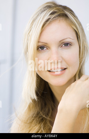 Junge Frau lächelt in die Kamera, Porträt Stockfoto