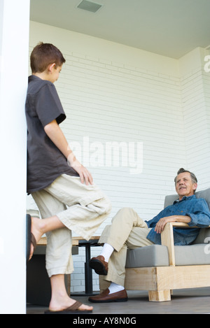 Großvater und Enkel von Angesicht zu Angesicht auf Veranda, Mann, sitzend, junge Stand Stockfoto