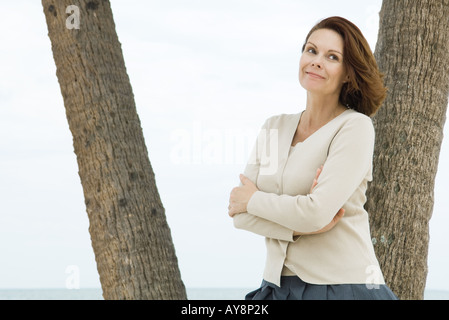 Reife Frau gelehnt Palme, Lächeln Stockfoto