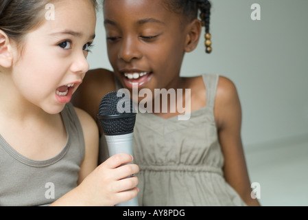 Zwei kleine Mädchen singen in Mikrofon zusammen, Nahaufnahme Stockfoto