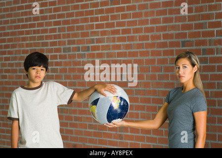 Frau und junge Holding Globe eingewickelt in Bandagen, beide Blick in die Kamera Stockfoto