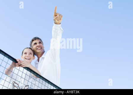Mann stand im Freien mit Tochter, in den Himmel, beide auf der Suche nach oben und lächelnd, niedrigen Winkel Ansicht Stockfoto