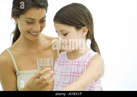 Frau hält Glas Wasser für Mädchen Stockfoto