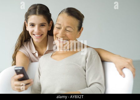 Preteen Mädchen zeigt Großmutter Handy Stockfoto