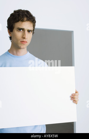 Mann mit Schild, gerunzelter Stirn in die Kamera Stockfoto