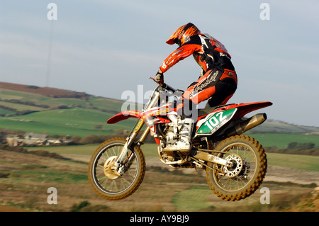 ein Kerl Fahrer auf einem Motocross-Galle-Motorrad springen und Rennen große Luft Stockfoto