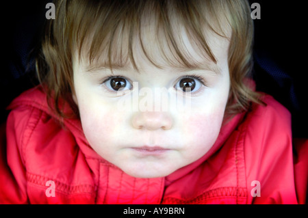 Baby Mädchen Kleinkind ein Jahr alt Gesicht kostbare Schönheit Brünette kaukasischen Kopf Porträt roten Mantel Jacke braune Augen Stockfoto