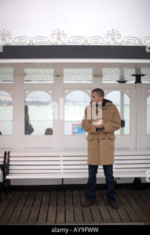 Mann in Dufflecoat auf Palace Pier in Brighton, UK Stockfoto