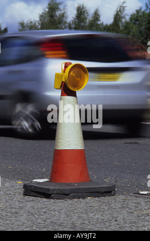 Fahrzeug vorbei an Kegel und Warnlicht bei Straßenbauarbeiten auf zweispurigen uk Stockfoto