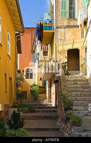 Eine typische schmale Straße gemalt mit warmen Farben im Dorf von Villefranche-Sur-Mer, in der Nähe von Nizza an der Cote d ' Azur, Frankreich Stockfoto