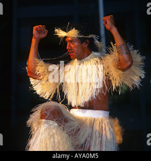 Lächelnd Tahitian Tänzer in Tracht trägt Grass Rock & Top mit Stirnband und erhobenen Armen Stockfoto