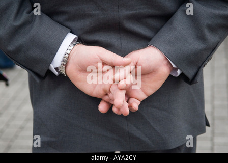 Mann in grauem Anzug mit aneinander gefalteten Händen hinter dem Rücken Detail Nahaufnahme. Stratford East London 2008 UK 2000s HOMER SYKES Stockfoto