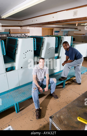 Porträt der Arbeiter neben einer Druckmaschine Stockfoto