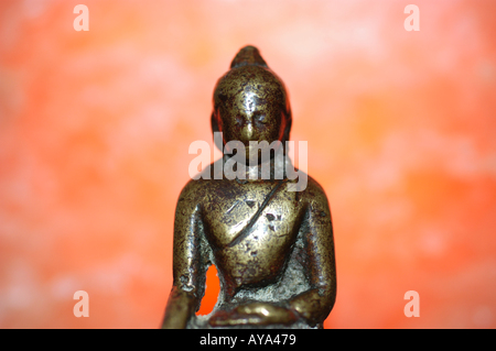 Buddha gegen eine Orange beleuchteten Hintergrund Stockfoto