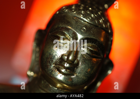 Buddha gegen eine Orange beleuchteten Hintergrund Stockfoto