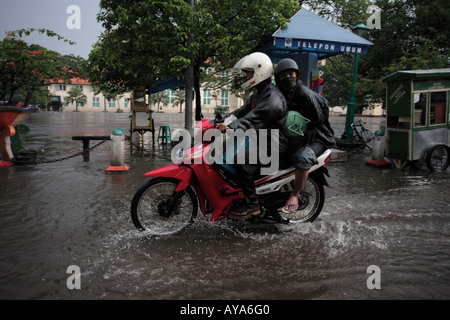 Indonesien Jakarta Motorrad-Taxi Fahrt durch tiefe Pools von Wasser nach Regen Sturm in der Nähe von Kota Station Überschwemmung Stockfoto