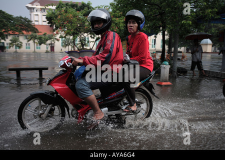 Indonesien Jakarta Motorrad-Taxi Fahrt durch tiefe Pools von Wasser nach Regen Sturm in der Nähe von Kota Station Überschwemmung Stockfoto