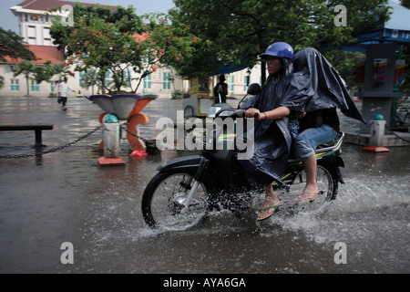 Indonesien Jakarta Motorrad-Taxi Fahrt durch tiefe Pools von Wasser nach Regen Sturm in der Nähe von Kota Station Überschwemmung Stockfoto