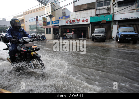 Indonesien Jakarta Motorrad-Taxi Fahrt durch tiefe Pools von Wasser nach Regen Sturm in der Nähe von Kota Station Überschwemmung Stockfoto