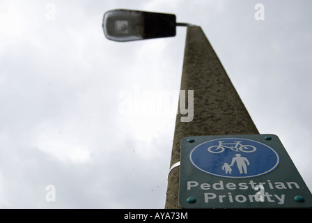 britische Zeichen an einen Laternenpfahl Fußgänger Priorität auf einem Wanderweg, der auch von Radfahrern genutzt angibt befestigt. Stockfoto