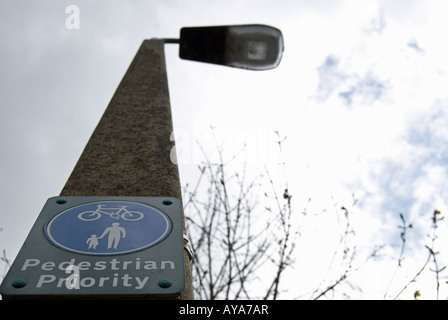 britische Zeichen an einen Laternenpfahl Fußgänger Priorität auf einem Wanderweg, der auch von Radfahrern genutzt angibt befestigt. Stockfoto