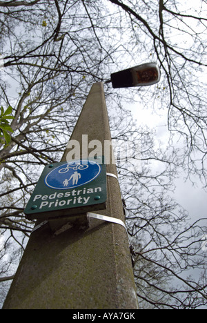 britische Zeichen an einen Laternenpfahl Fußgänger Priorität auf einem Wanderweg, der auch von Radfahrern genutzt angibt befestigt. Stockfoto