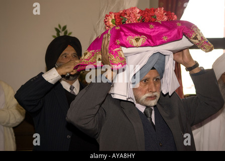 Sikhs im inneren Tempels (Gurdwara) mit der Heiligen Schrift auf dem Festival von Vaisakhi, Siri Guru Singh Sabha, Hounslow, Middlesex, Großbritannien. März 2008. Stockfoto