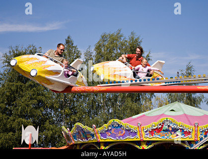 Erwachsene und Kinder auf Kirmes Flugzeug fahren Frauenau Bayern Deutschland Stockfoto