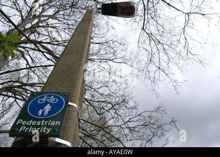 britische Zeichen an einen Laternenpfahl Fußgänger Priorität auf einem Wanderweg, der auch von Radfahrern genutzt angibt befestigt. Stockfoto