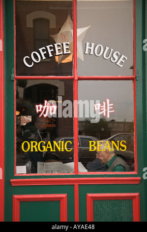 Mann liest Papier im Kaffee-Haus-Fenster Chinatown Victoria British Columbia Stockfoto