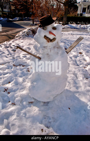 Einen klassischen Schneemann mit Steinen für Augen und Mund eine Karotte als Nase und in einen alten Hut geschmückt Stockfoto