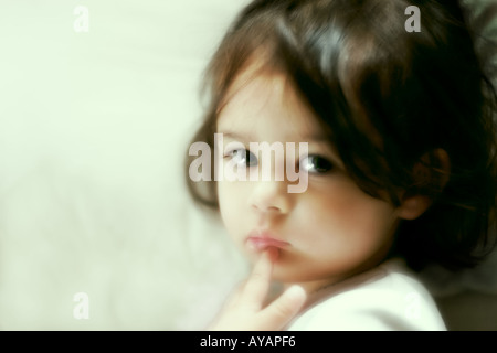 Kleines Mädchen im Bett liegend in tiefen Gedanken Stockfoto