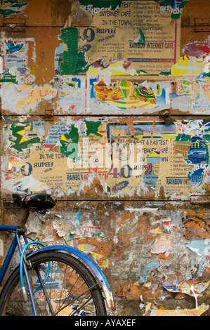 Fahrrad gelehnt zerrissene Plakate an einer Wand in Negombo, in der Nähe von Colombo, Sri Lanka. Stockfoto