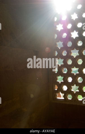 Sonne, durch das Spalier arbeiten Jalis die Quwwat-Ul-Islam-Moschee in Alt-Delhi, Indien. Stockfoto