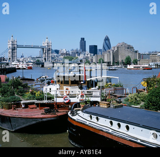 Blick über die Themse, die City of London und Tower Bridge im Vordergrund sind Hausboote Stockfoto