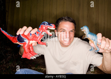 Mann spielt mit Spielzeug Dinosaurier Stockfoto