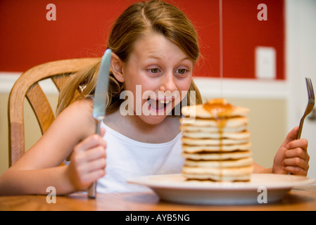 Kind bereit zu riesigen Stapel von Pfannkuchen essen Stockfoto