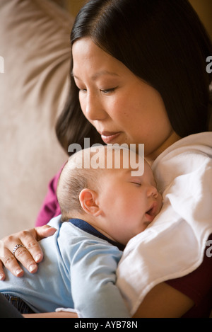 Nahaufnahme eines Säuglings jungen beim Einschlafen, während er von seiner Mutter statt Stockfoto