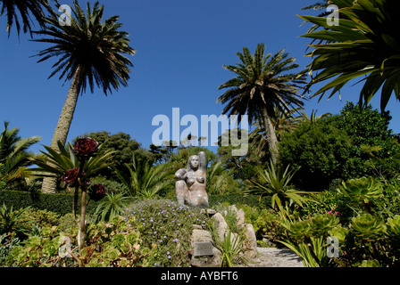 Statue von Gaia Mutter Erde unter Palmen an einem hellen Sommertag mit blauem Himmel in Tresco Abbey Gardens Stockfoto